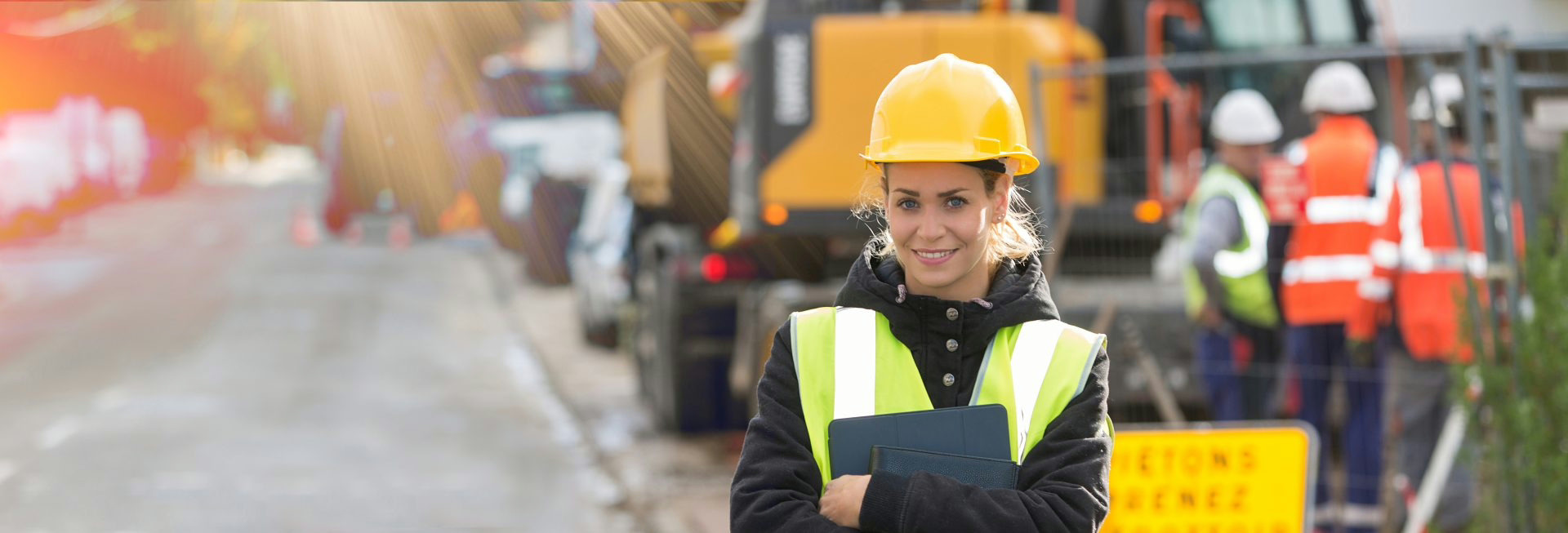 Construction safety professional wearing hard hat and high visibility vest at a worksite