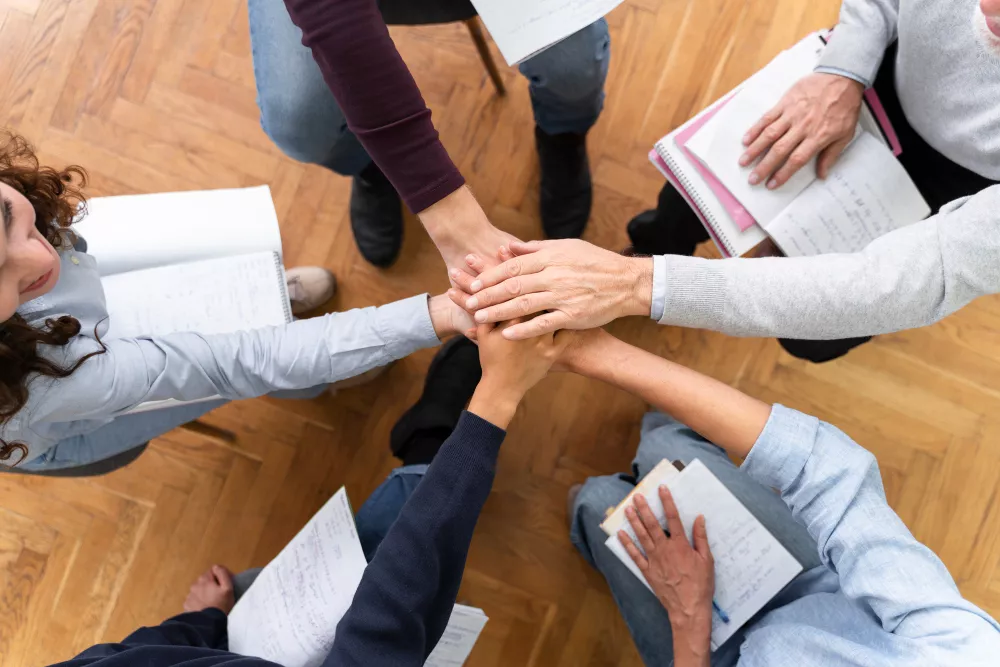Team Members Joining Hands in Collaborative Circle